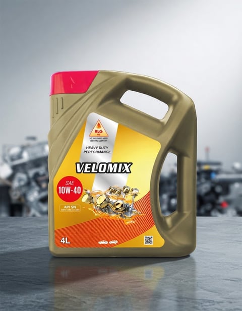 A 4L bottle of Velomix 10W-40 heavy duty performance motor oil with yellow and orange label on an industrial background